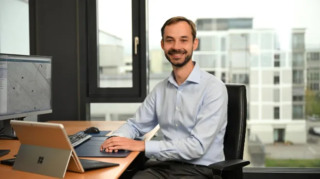 Julian Wruk sitzt vor einem PC, der das Grid Cockpit zeigt