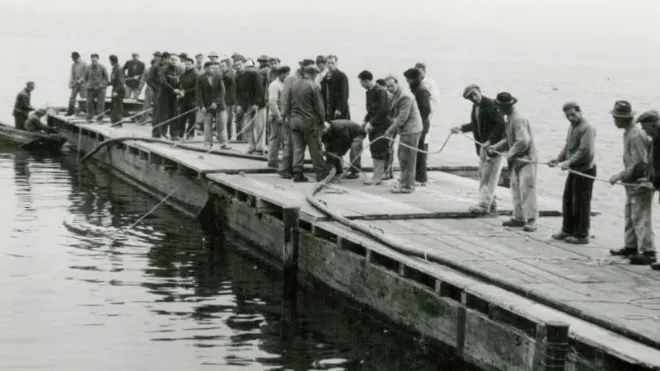 Heute werden vor allem grosse Maschinen zum Verlegen von Kabeln im See eingesetzt. Hier sieht man ein Bild vom Verlegen des Seekabels zwischen Herrliberg und Thalwil aus dem Jahr 1954. Damals standen viele Menschen statt Maschinen im Einsatz.