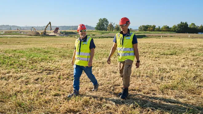 Bauleiter laufen übers Feld