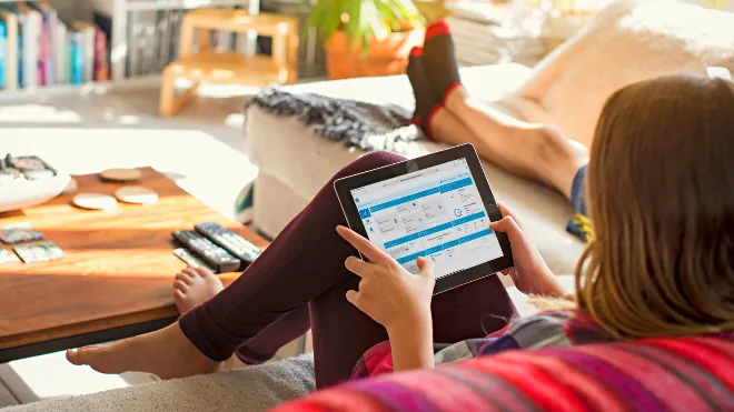 Frau blickt auf Tablet, EKZ Energiemanager App