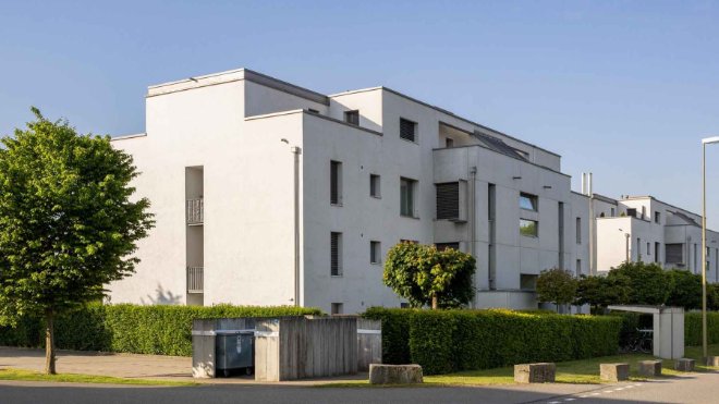 Moderne Mehrfamilienhäuser mit Tiefgarage. Wer zur Miete in einem Mehrfamilienhaus wohnt, kann auch Zuhause sein Elektroauto laden. Die Herangehensweise bis zur Installation der Wallbox beim Parkplatz in der Tiefgarage ist aber anders. Verwaltung und Eigentümerschaft müssen hinzugezogen werden. Hier lohnt sich eine Ladelösung wie jene von EKZ.