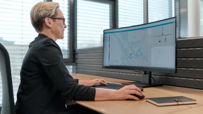 Eine EKZ-Mitarbeiterin sitzt vor dem Grid Cockpit