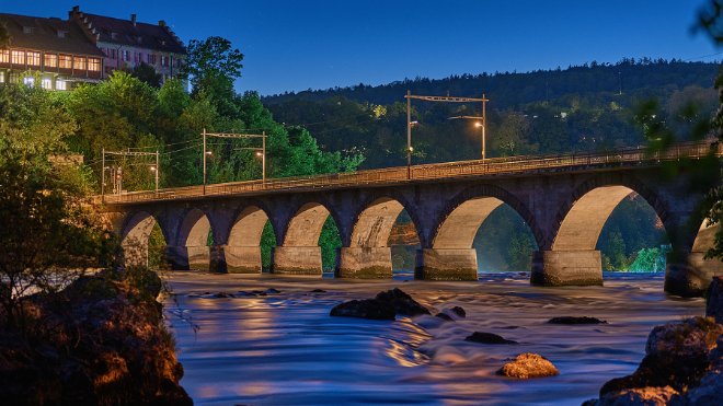 Auf dem Bild ist die SBB-Eisenbahnbrücke in Schaffhausen zu sehen, die dank dem modernen Beleuchtungskonzept von EKZ in neuem Licht erstrahlt.