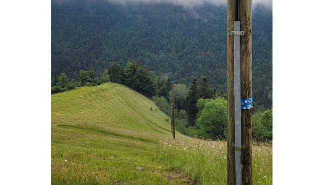 Diese Freileitung in die Strahlegg im Tösstal verschwindet. Links ist der zugeschüttete und bereits überwachsene Graben zu erkennen. 