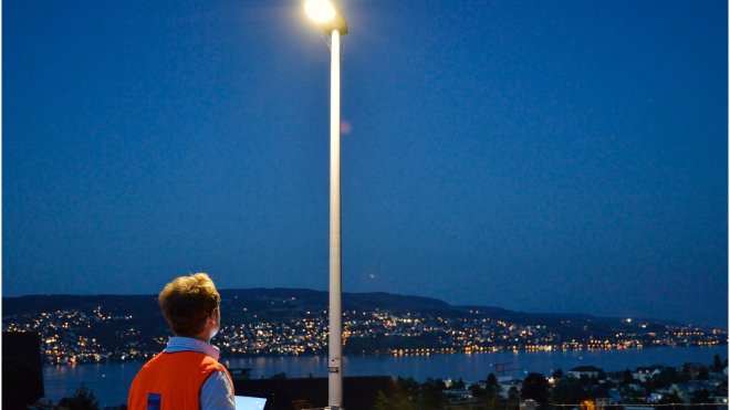Ein Mann überprüft die öffentliche Beleuchtung in einer Gemeinde am Zürichsee